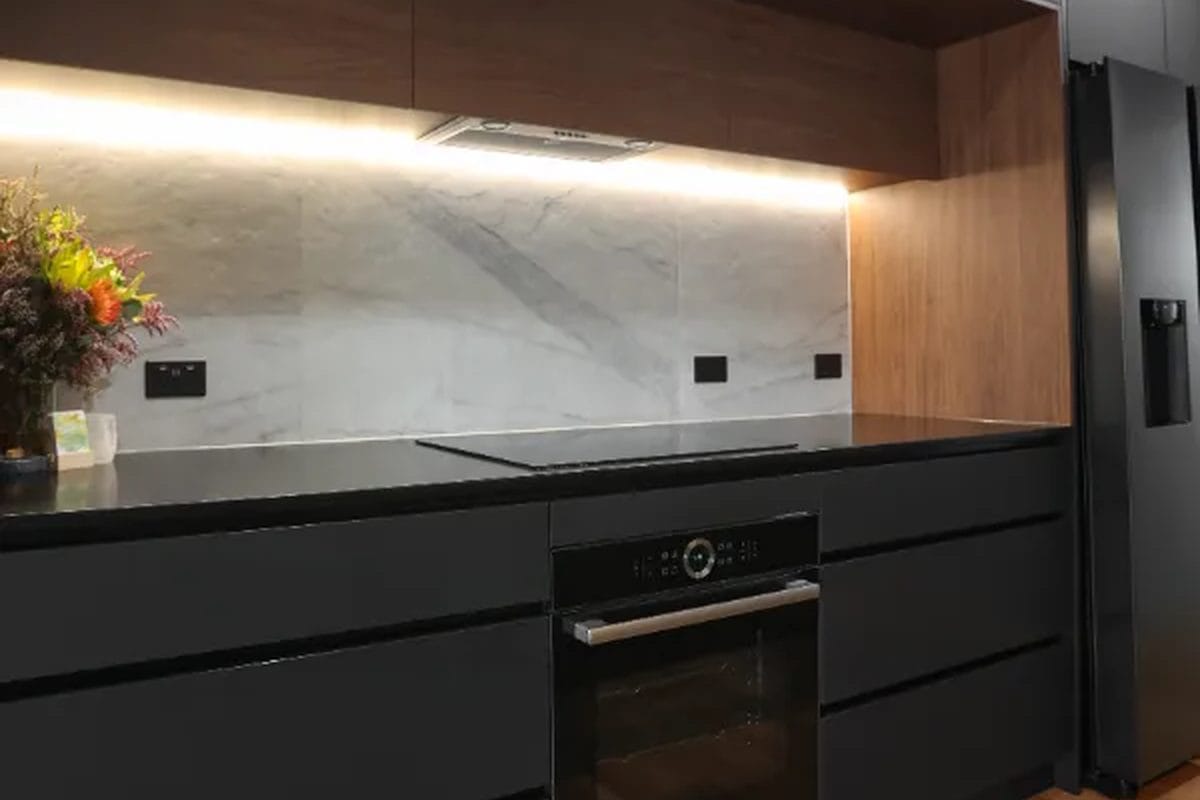Matte black slab fronts with timber overheads