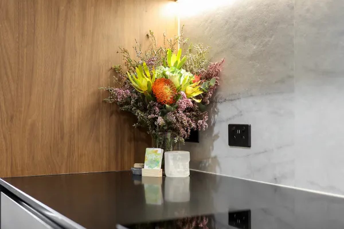 Stone benchtop edge against routed timber panel
